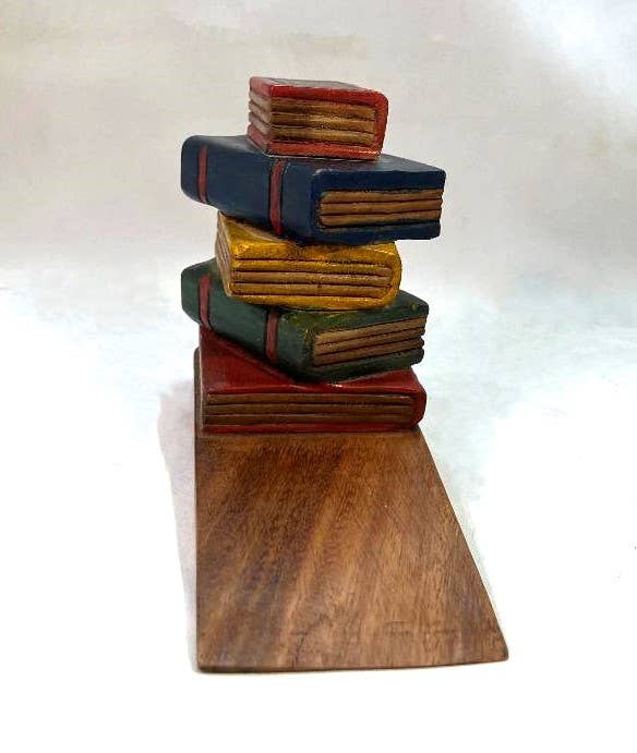 Hand-carved stacked book doorstop in vintage red, green, and gold tones