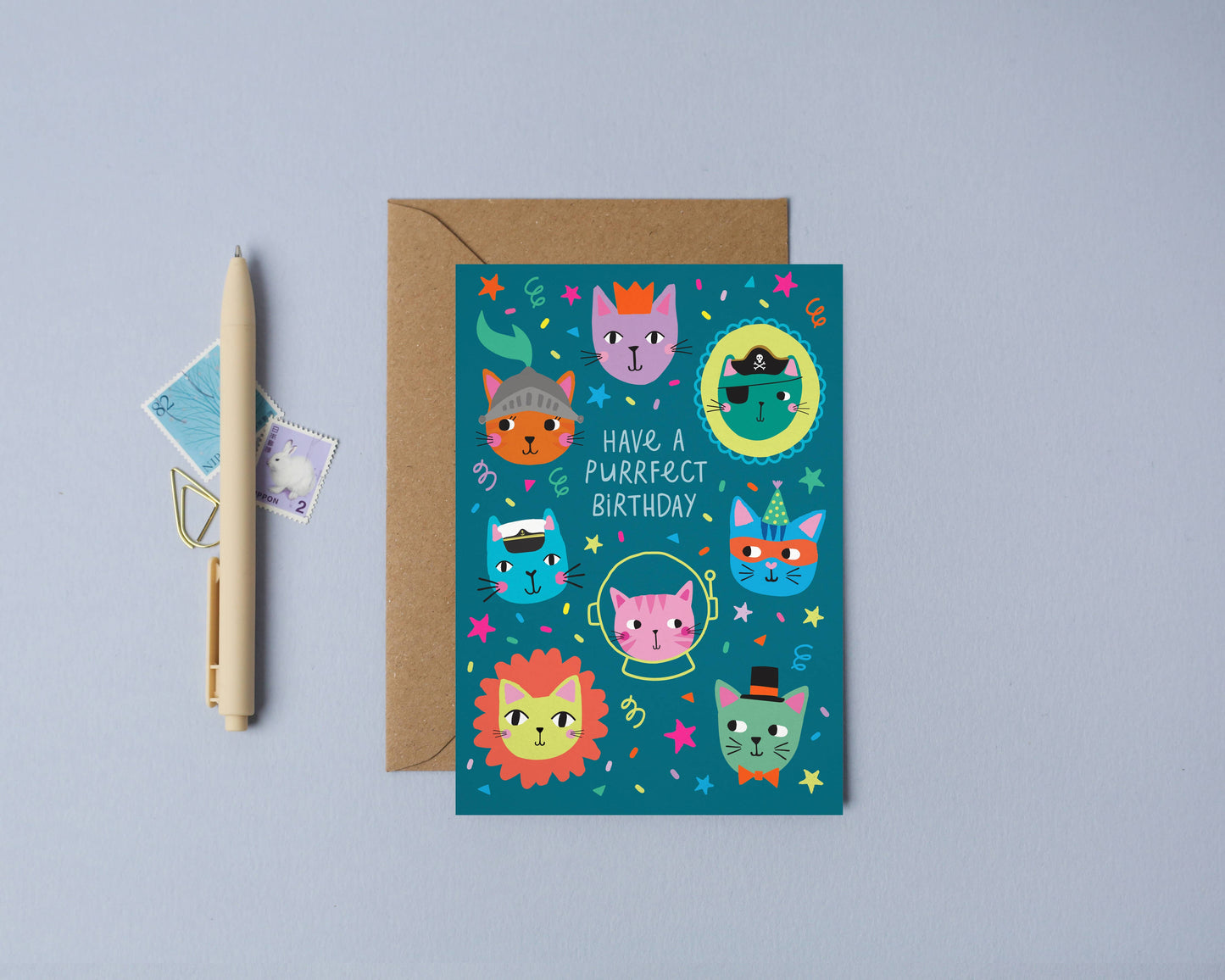 Colorful children’s birthday card with whimsical illustrated cats in costumes on a blue background