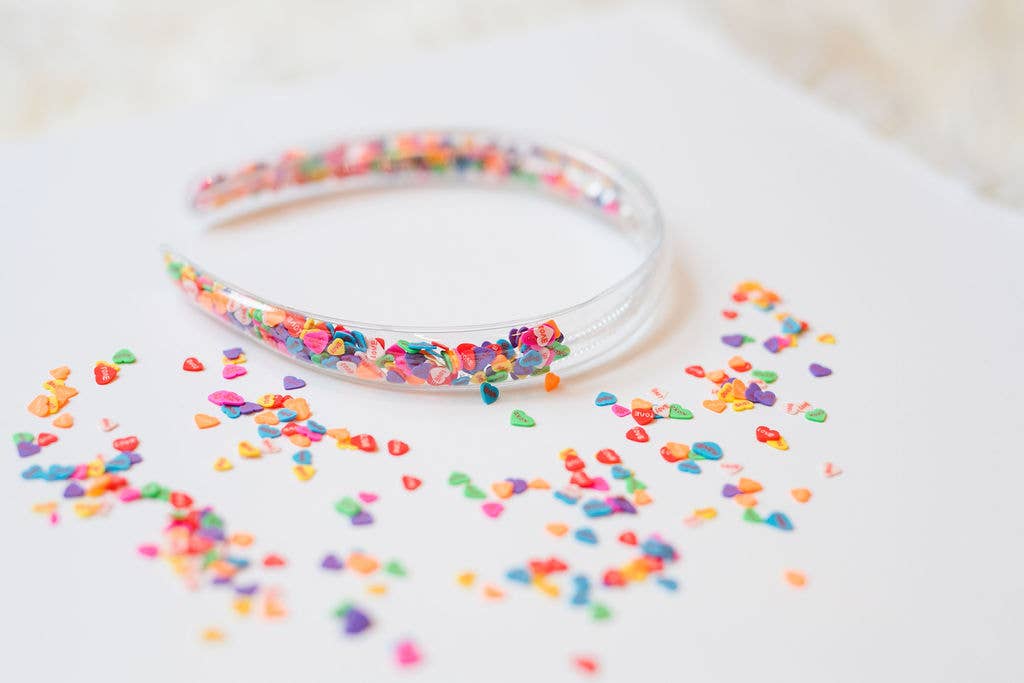 Clear headband filled with colorful candy heart confetti, perfect for festive fun.