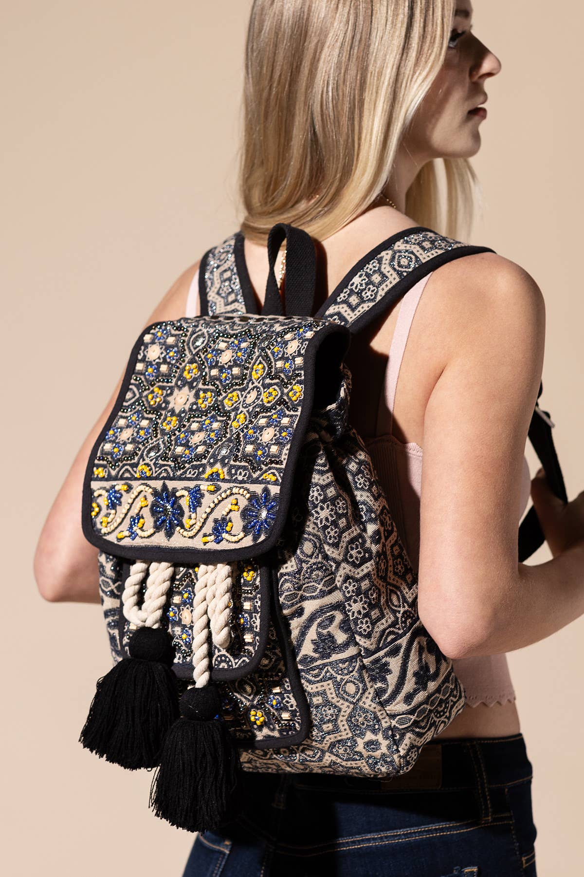 Hand-beaded bohemian backpack with a moon flower design, featuring intricate patterns and tassels.
