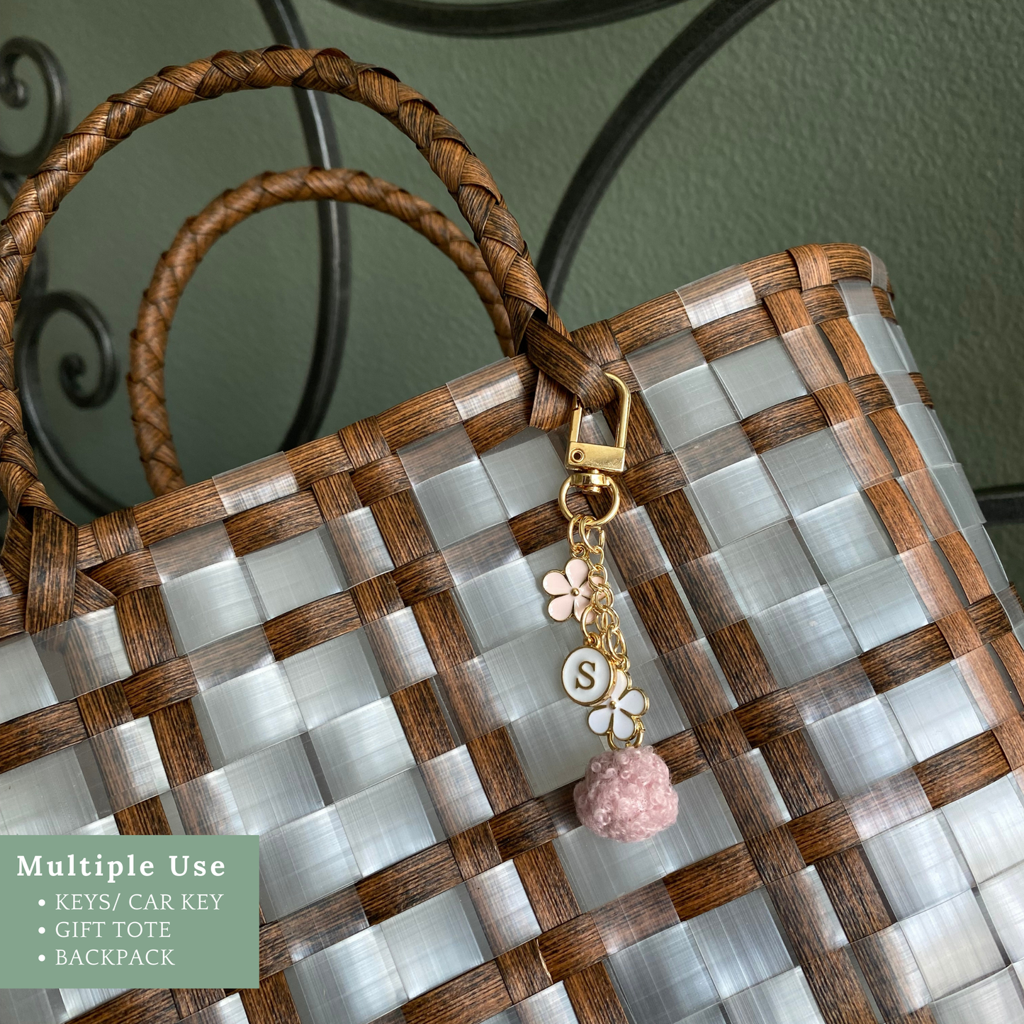 A floral initial keychain with a pom charm, featuring a gold clasp and letter "S," perfect for gifts for girls.
