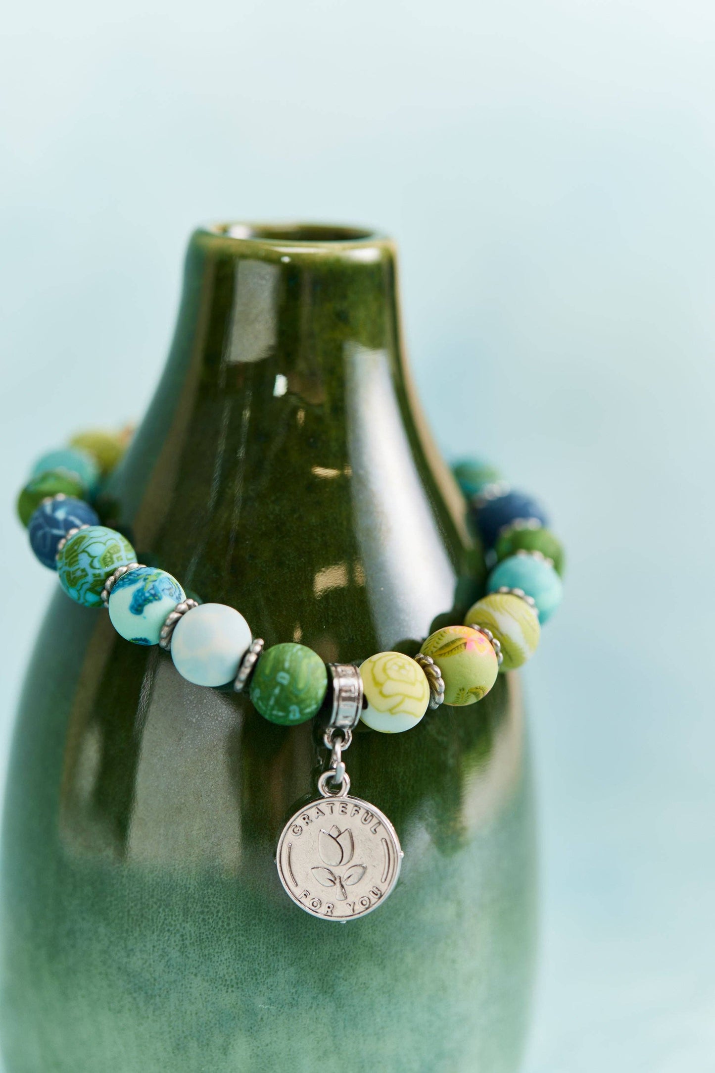Multicolor beaded friendship bracelet with a silver "Grateful for You" charm.