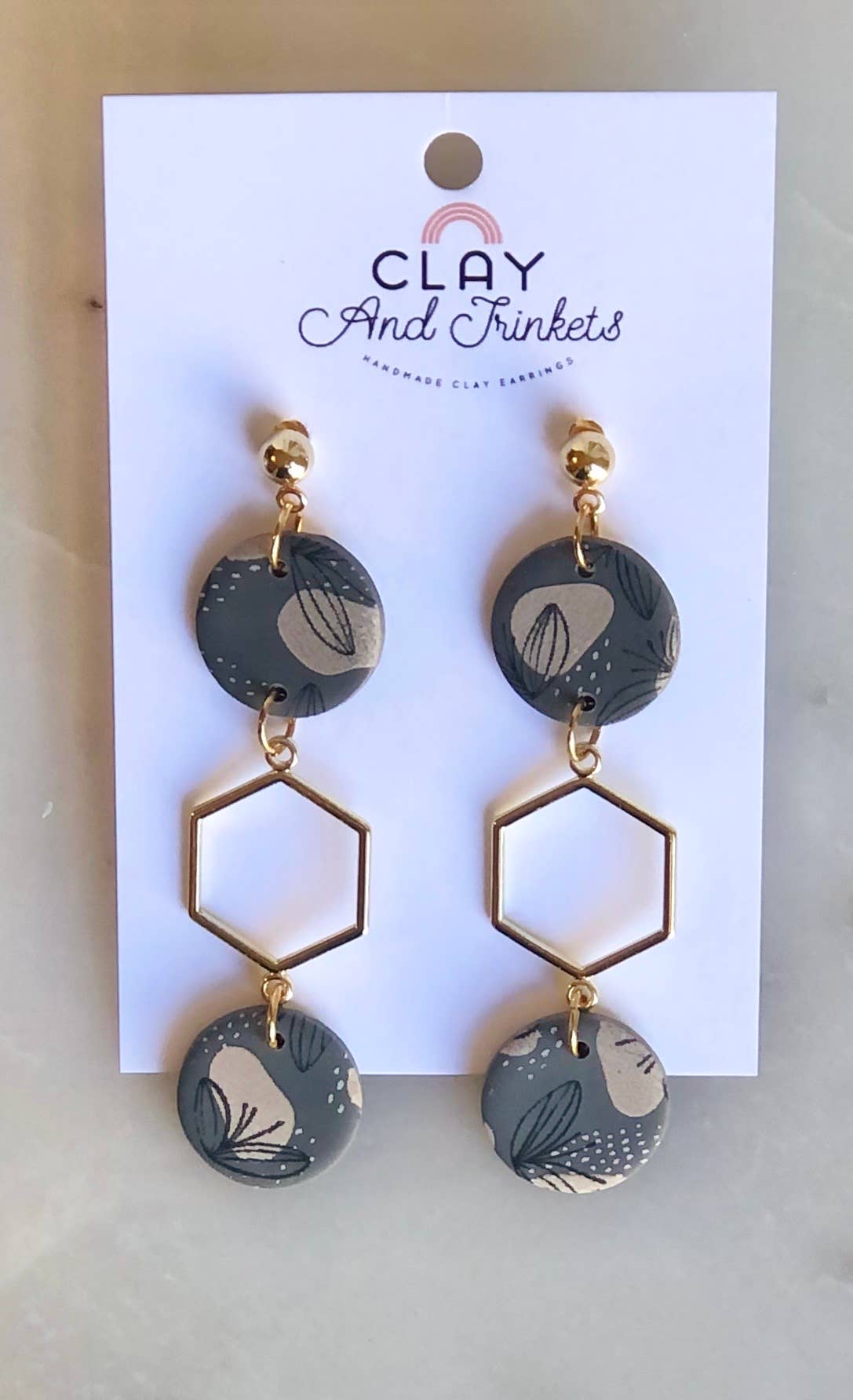 Dangling clay earrings with patterned discs and gold hexagon shapes