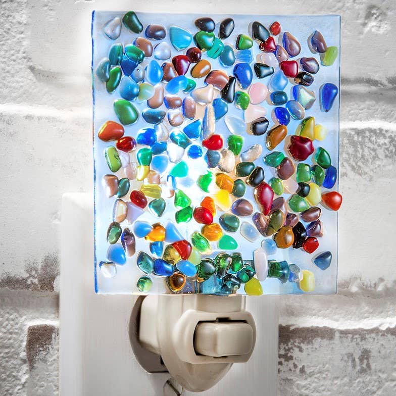 Colorful fused glass night light with pebble-like glass chips on a blue background