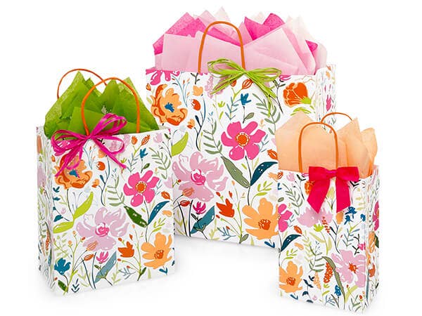 Brightly colored paper gift bags with wildflower prints, featuring ribbon handles and decorative bows.