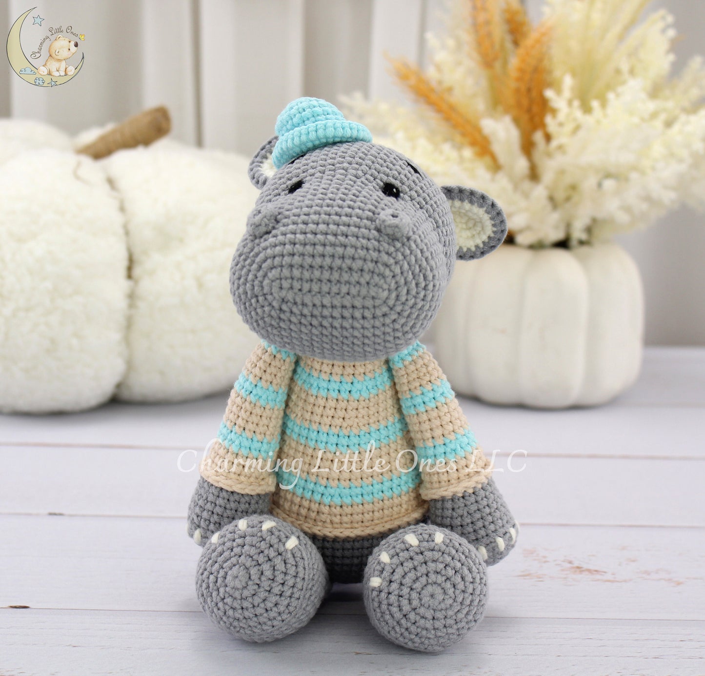 Handmade crochet hippo, 11 inches tall, in gray with a striped sweater and a light blue hat.