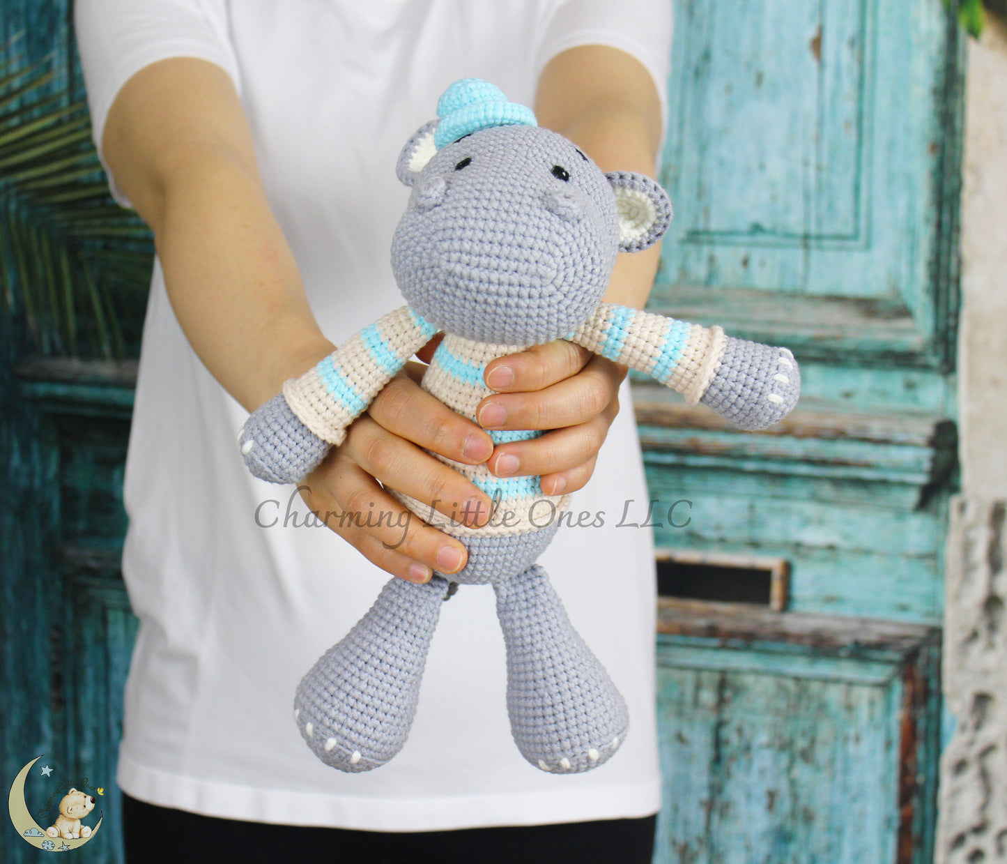 A handmade crochet hippo toy with light blue and white accents, 11" tall.