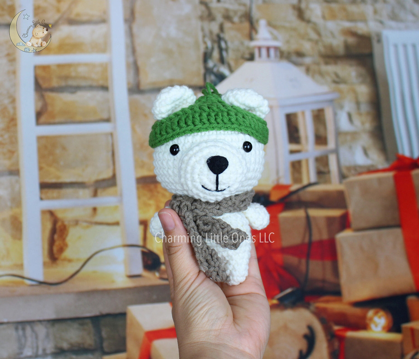 A handmade crochet Christmas polar bear ornament with a green hat and brown scarf, 6 inches tall.