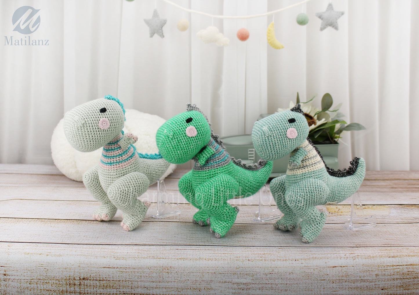 Handmade crochet TRex dinosaur in green, blue, and mint with striped patterns.