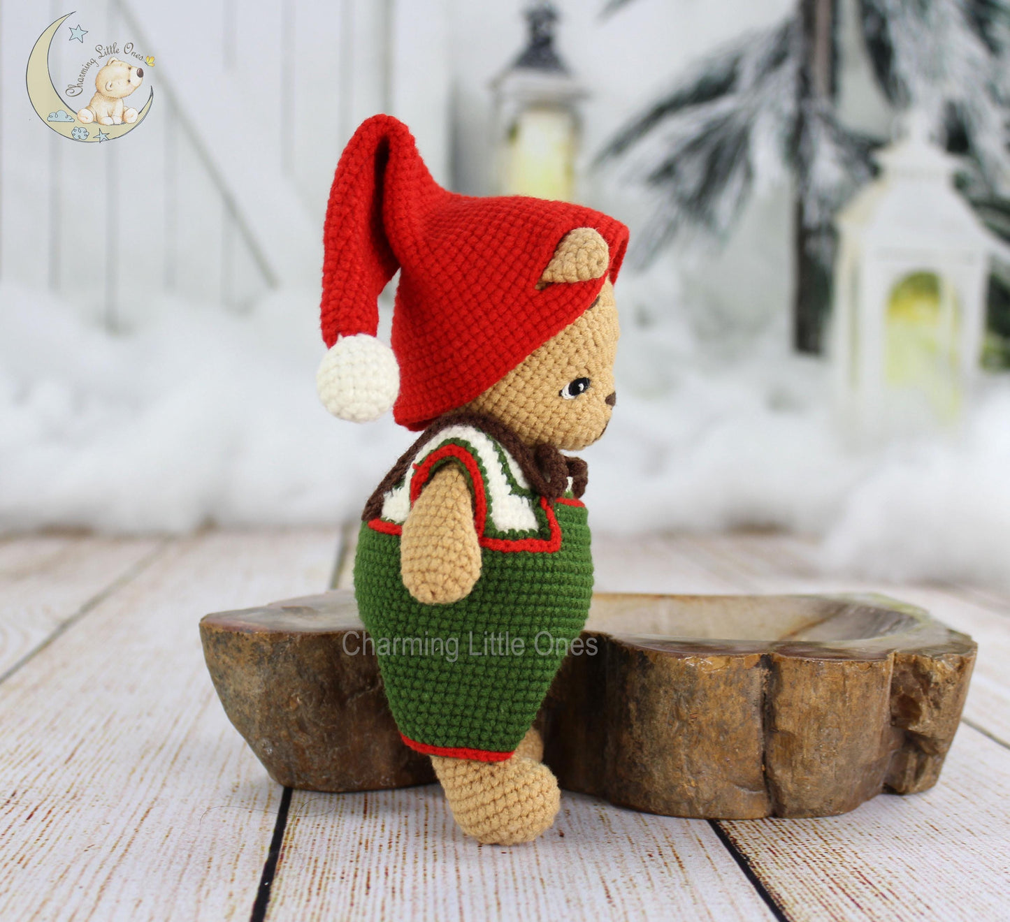 A handmade crochet Christmas bear wearing a red elf hat and green outfit, 8" tall.