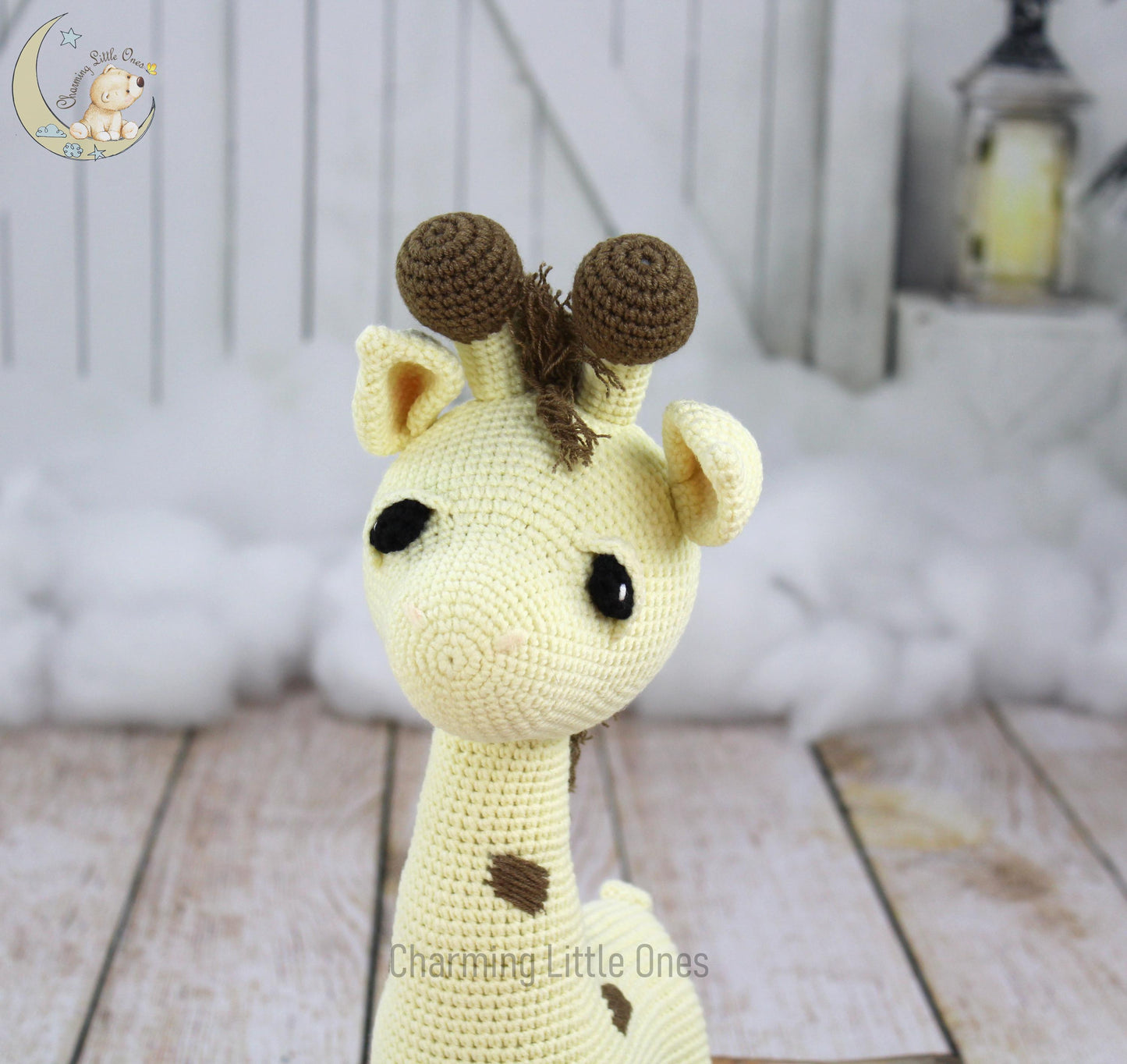 A handmade crochet giraffe with brown spots and two small horns, standing 14.5 inches tall.