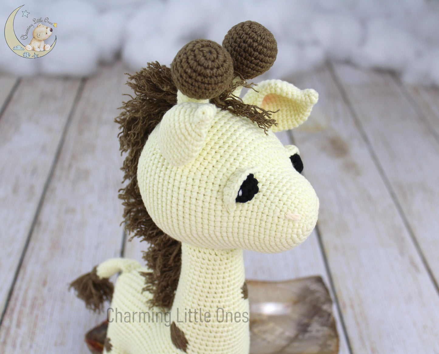 Handmade crochet giraffe toy, beige with brown spots, black bead eyes, and soft textures.
