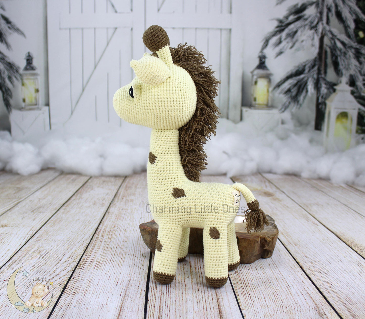 A handmade crochet giraffe with brown spots and a fluffy mane, standing on a wooden base.