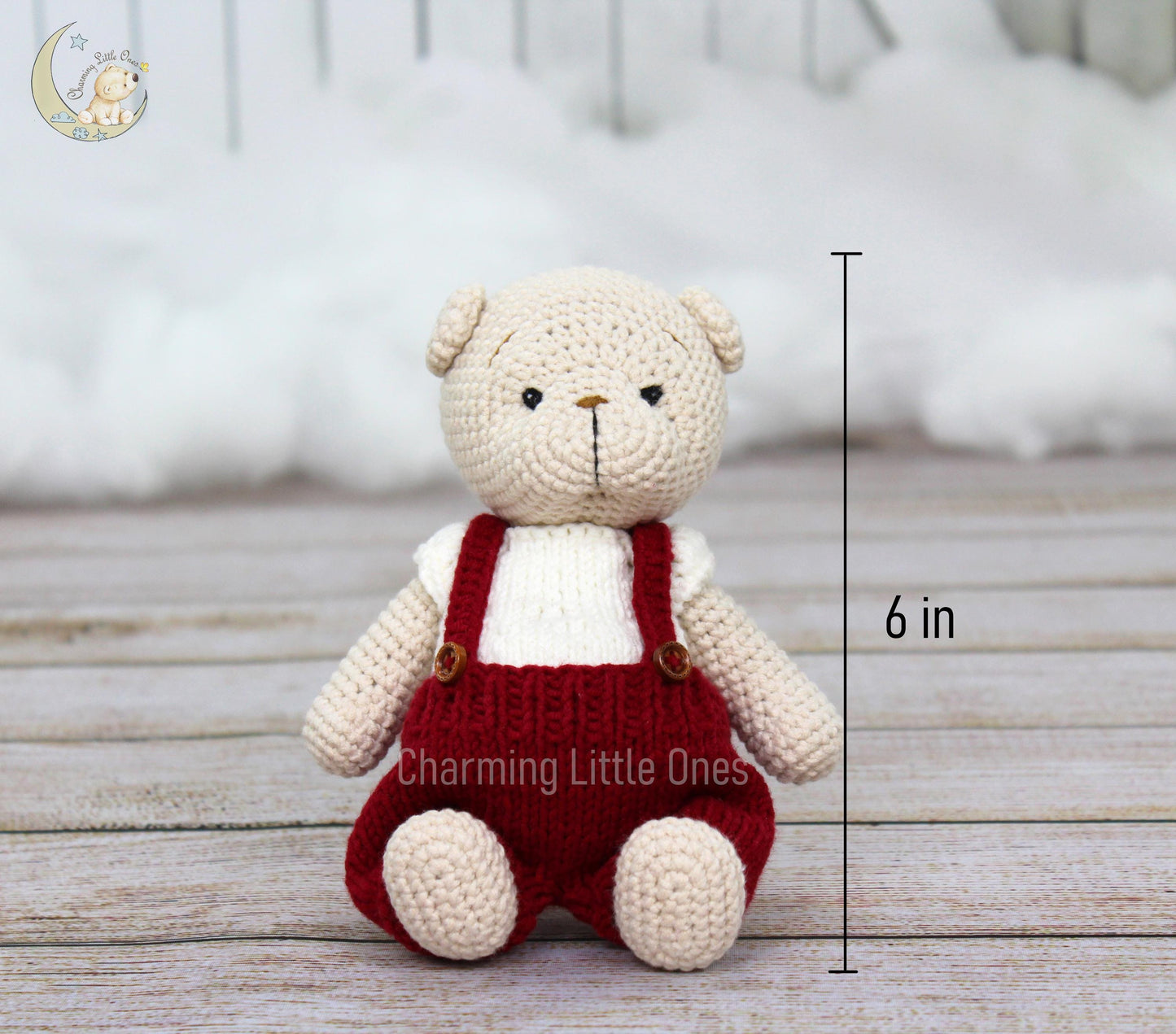 A handmade crochet Christmas bear in cream with red overalls, 6 inches tall.