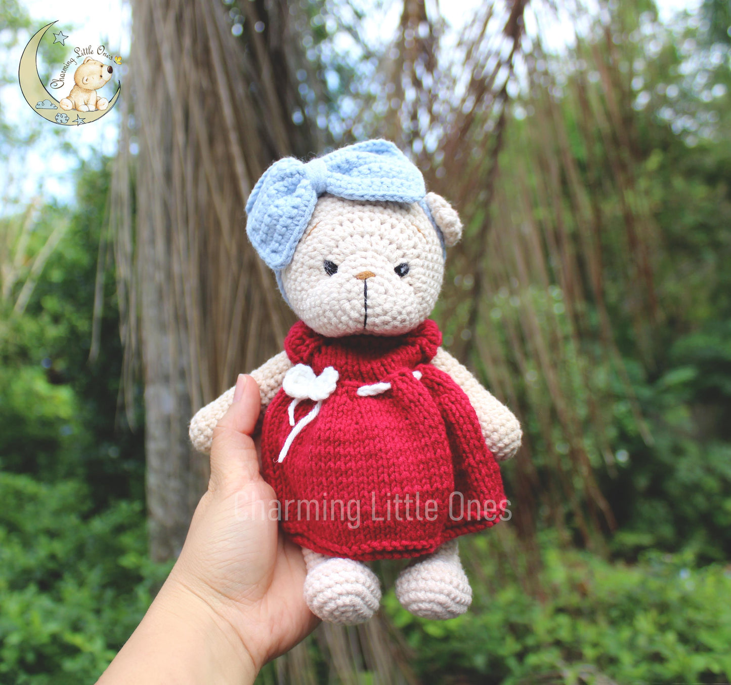 Handmade crochet bear in a red dress with white accents and a blue bow, perfect for Christmas.