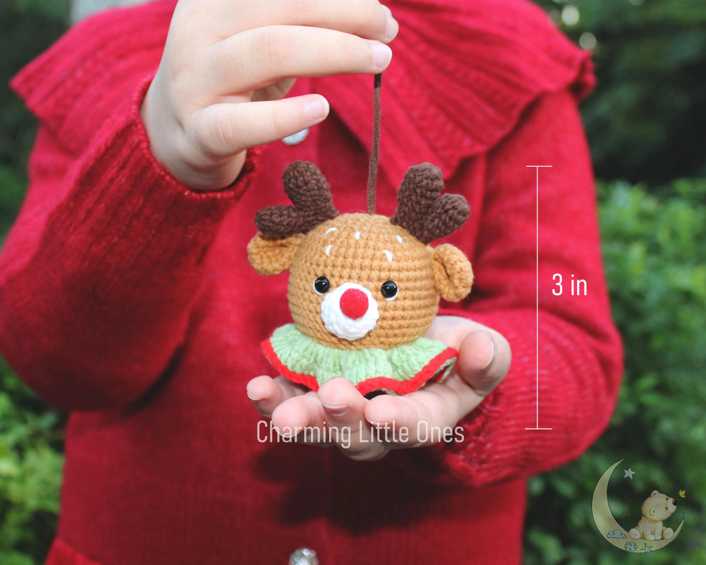 Handmade crochet plush reindeer ornament with brown antlers, red nose, and green collar, perfect for Christmas.