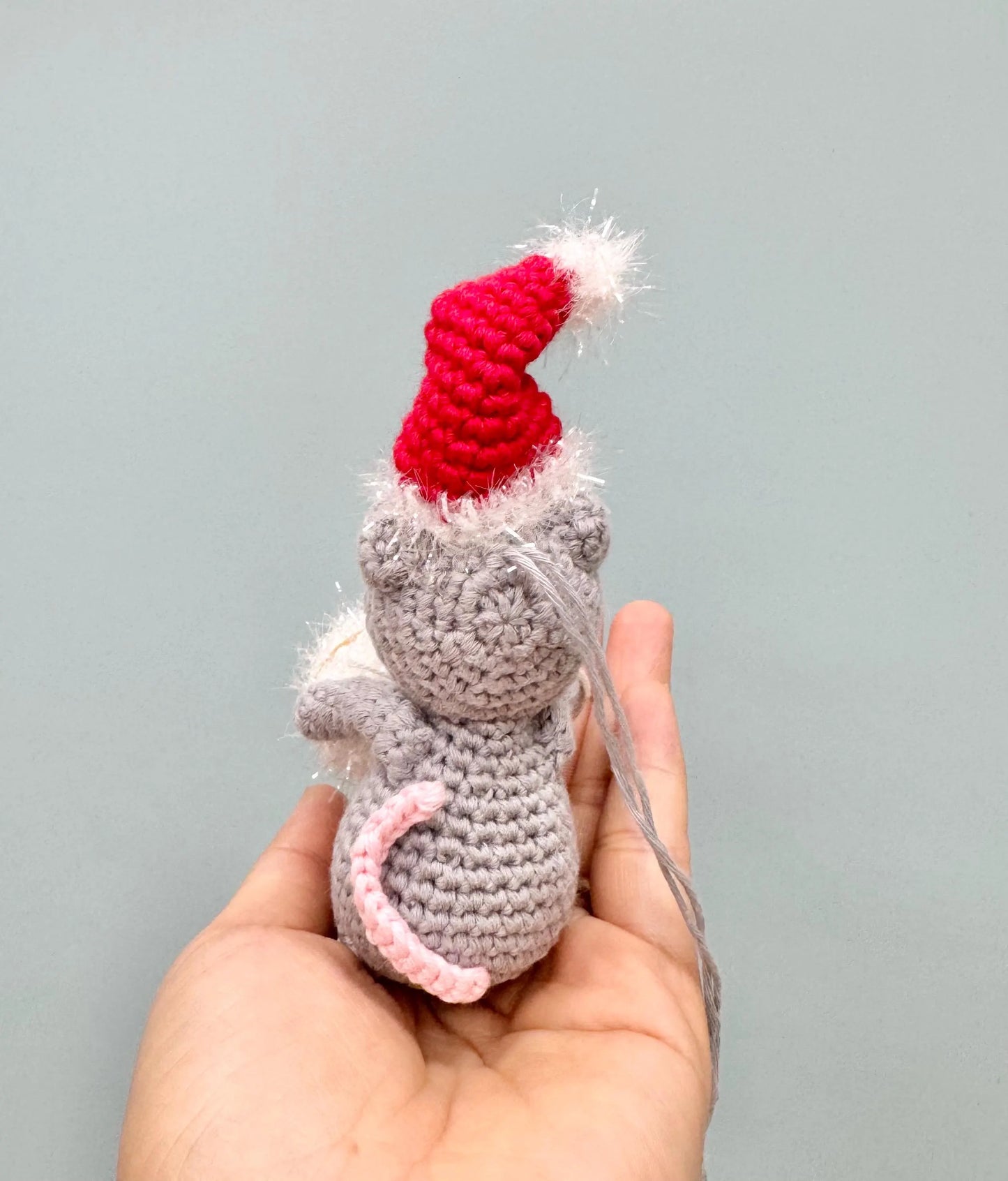 Crochet mouse ornament in gray with a red Santa hat, perfect for Christmas tree decoration.