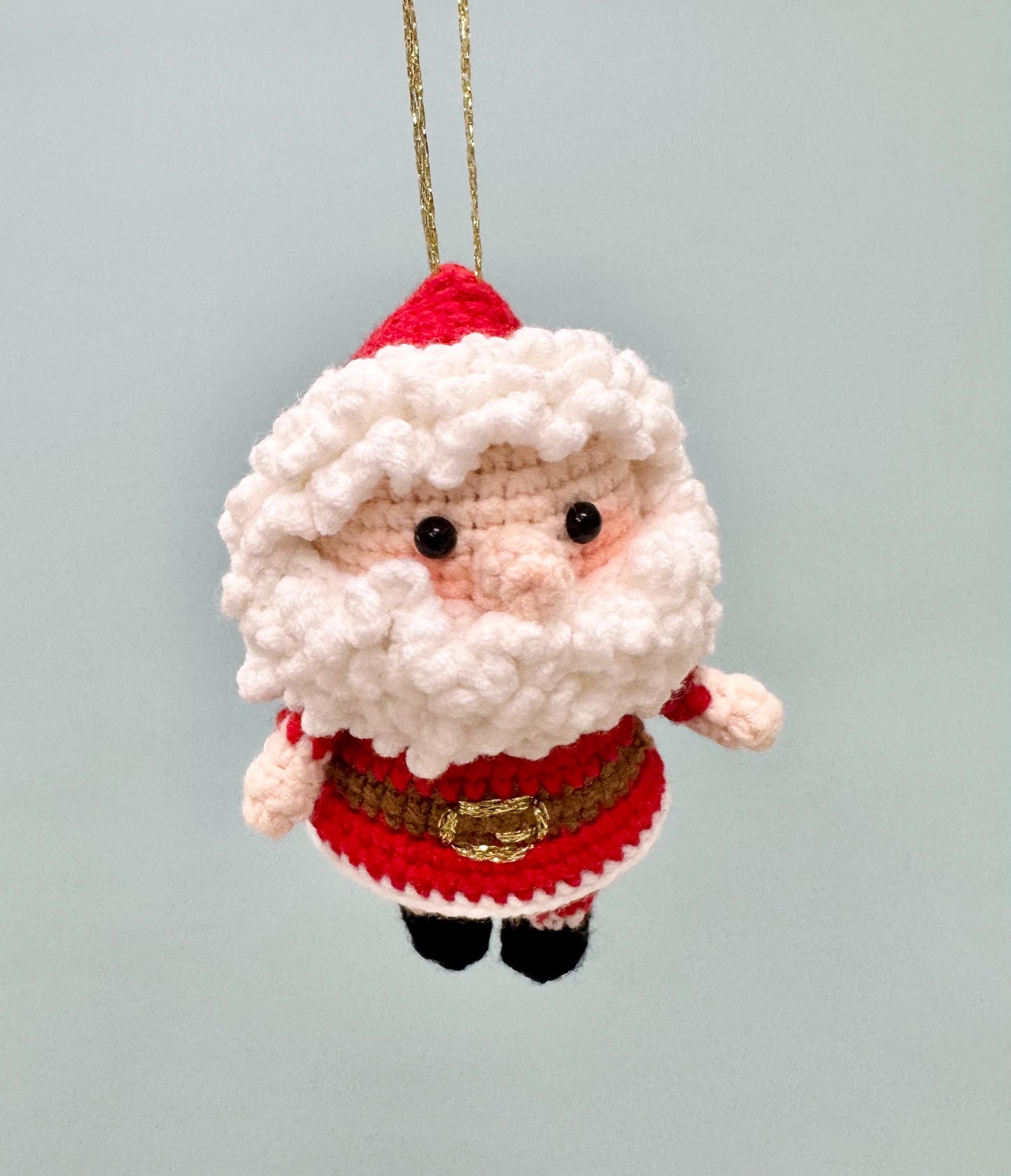 Crochet Santa Claus ornament with a red hat, white beard, and festive outfit, perfect for holiday decorating.