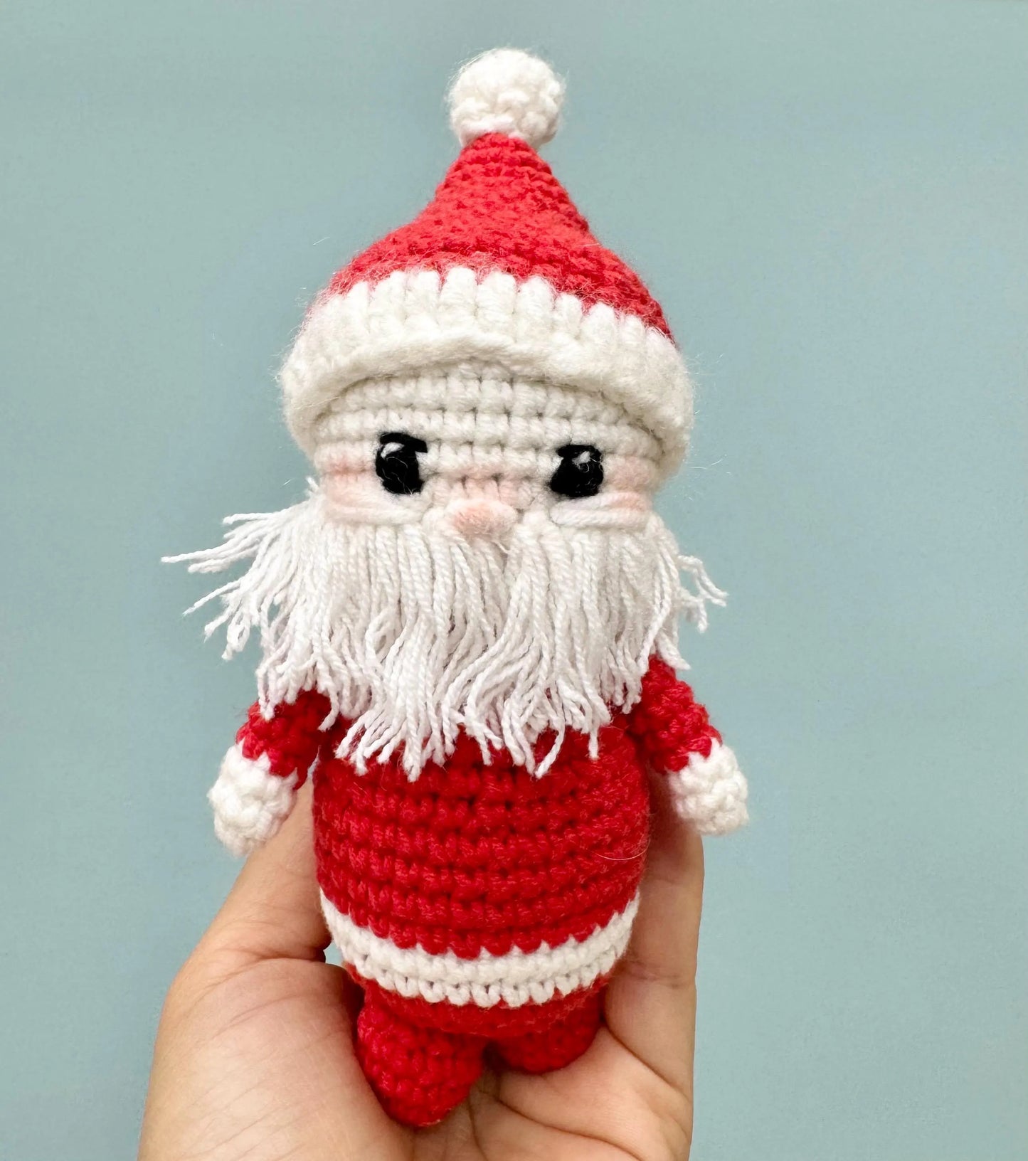 Handmade crochet Santa Claus ornament with a red and white outfit, fluffy white beard, and a cheerful expression.