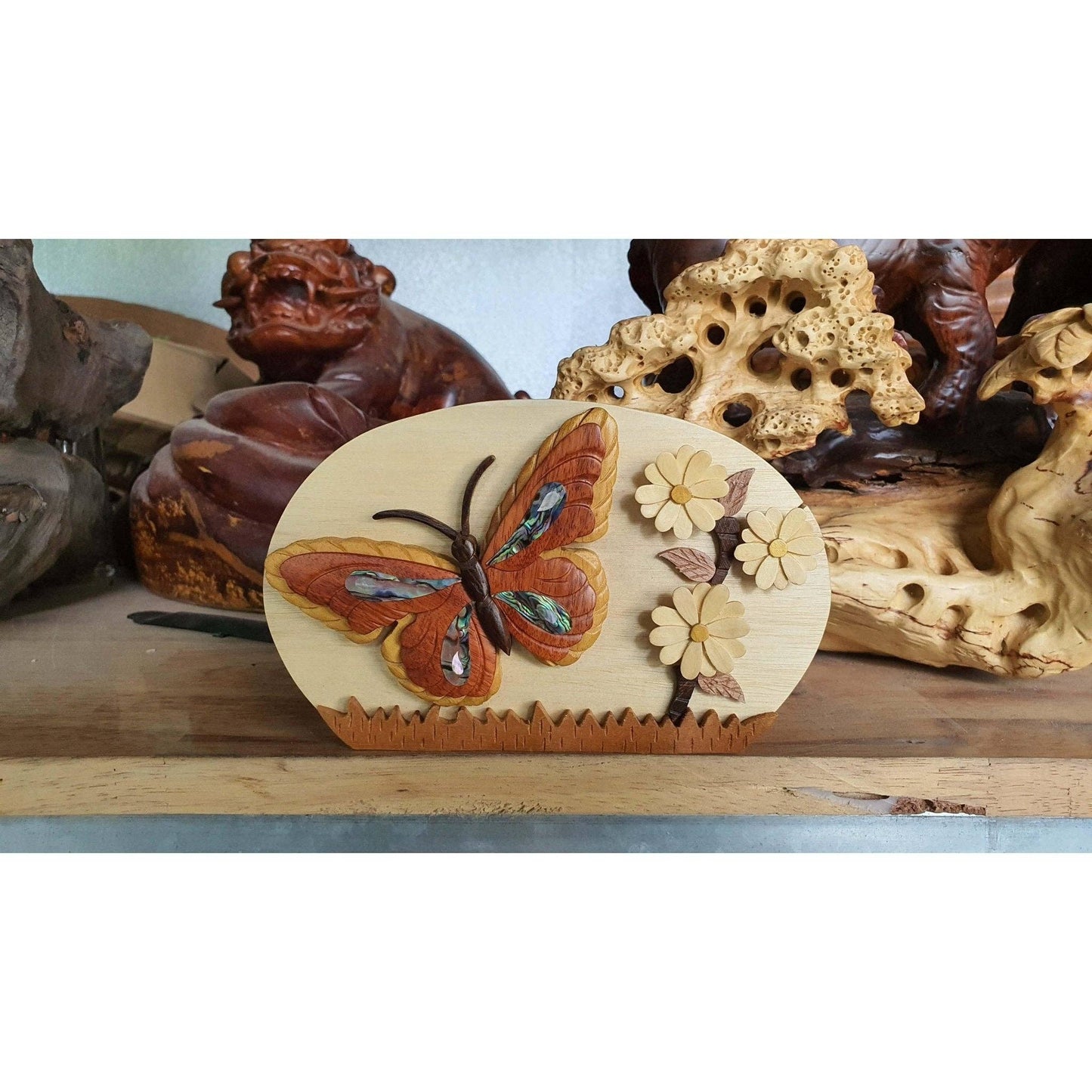 "Hand-carved wooden keepsake box featuring a vibrant butterfly and daisy design with mother of pearl inlays."