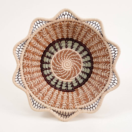 Handwoven basket with spiral and scalloped edge design in natural tones
