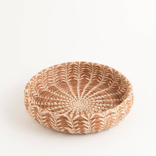 Shallow round woven basket with natural geometric pattern