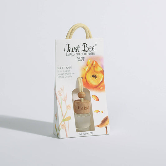 Small hanging diffuser with golden amber scent, featuring a wooden bead and clear glass bottle for small spaces.