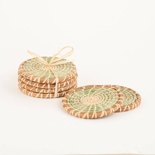 Set of four round green and tan handwoven coasters made from pine needle and wild grass.