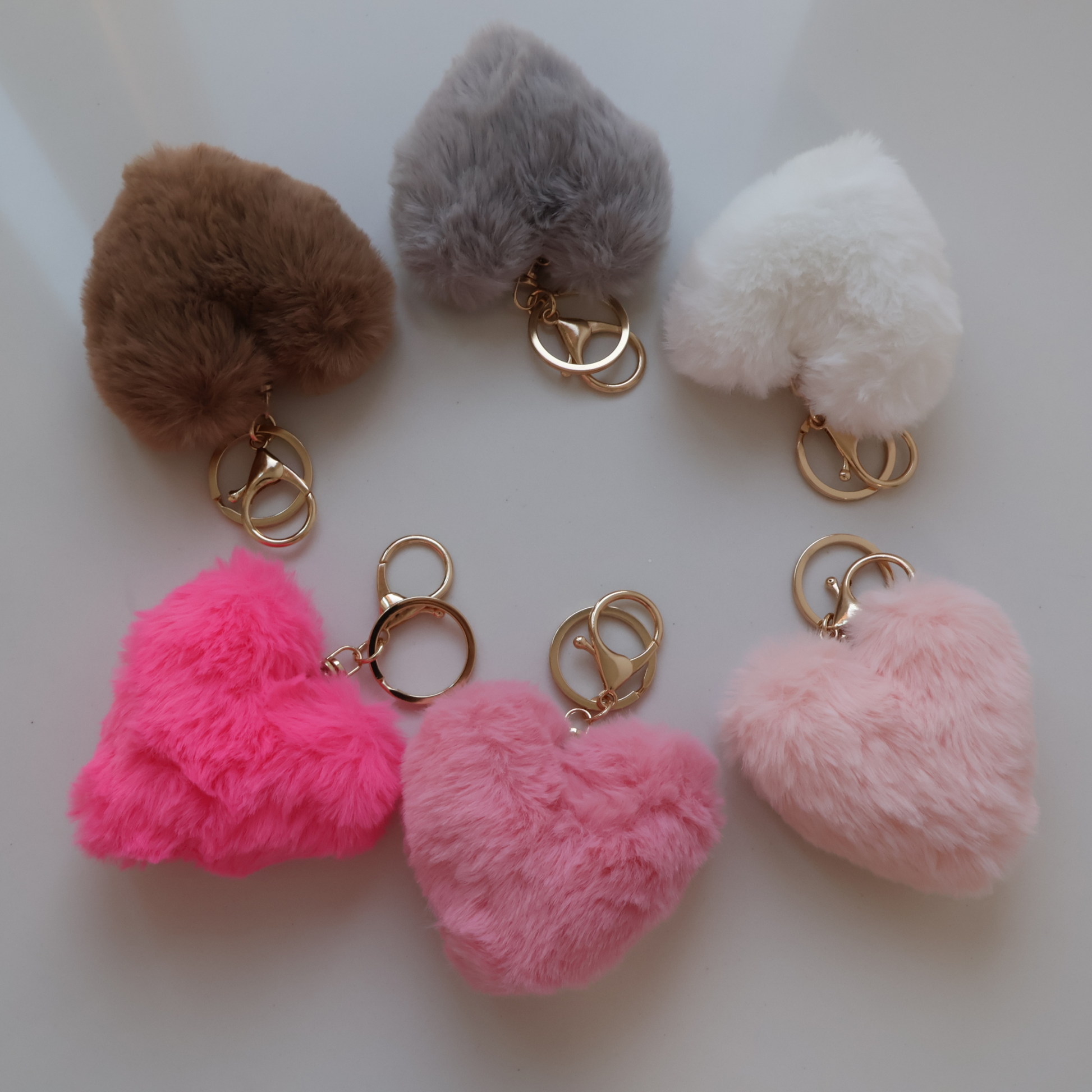 Assorted heart-shaped faux fur keychains with gold-tone clasps in multiple colors.