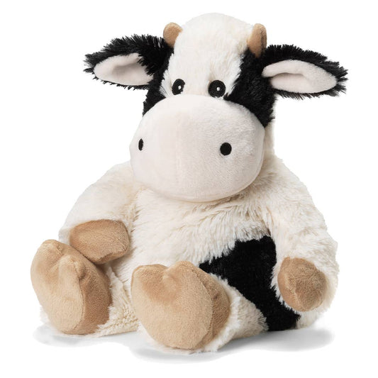 Soft plush cow with cream and black fur, floppy ears, and beige hooves; designed for microwavable warming.
