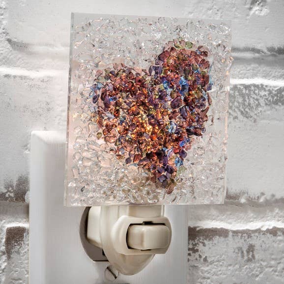 Fused glass heart night light with multicolored glass chips on a white outlet