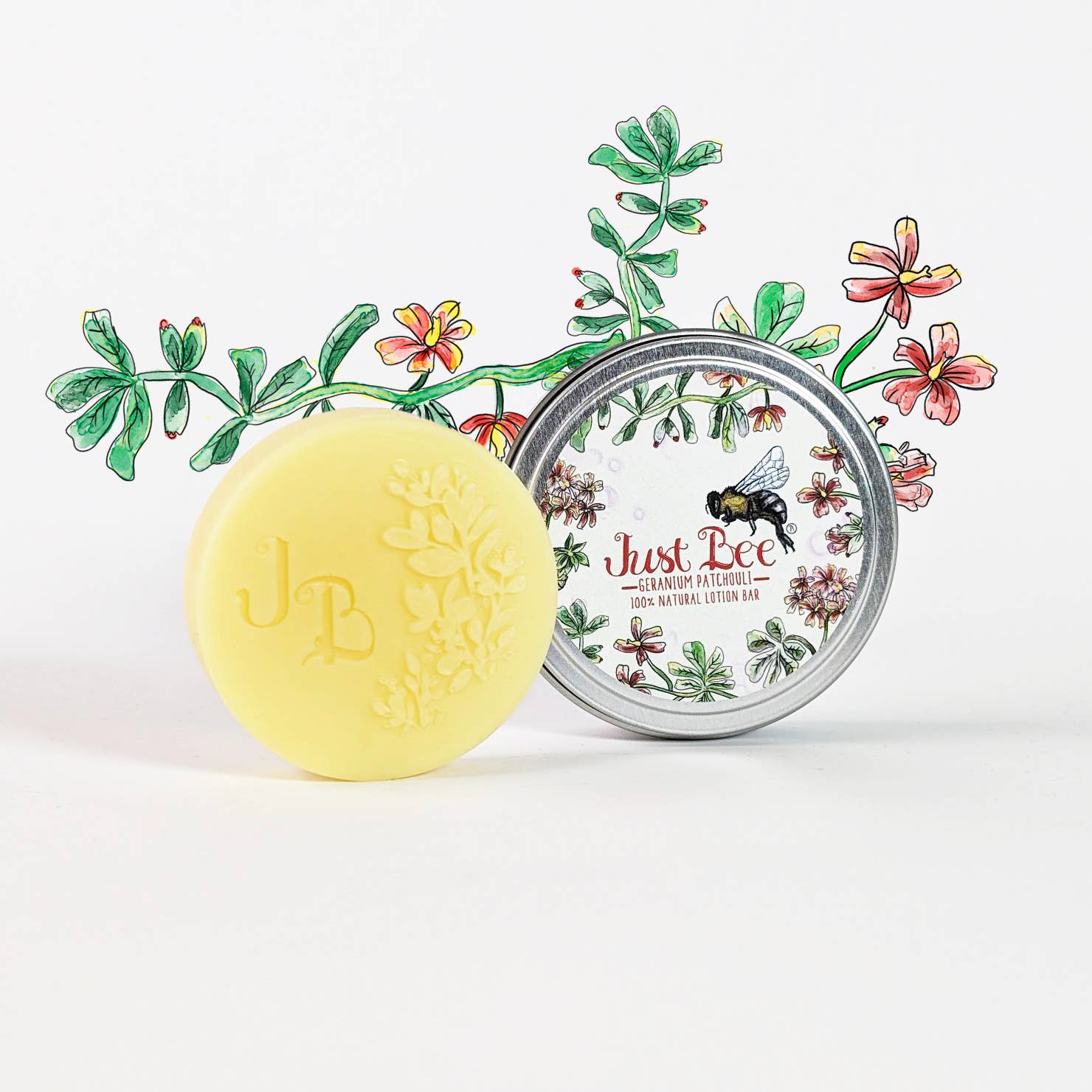Round yellow lotion bar with floral imprint next to illustrated tin lid