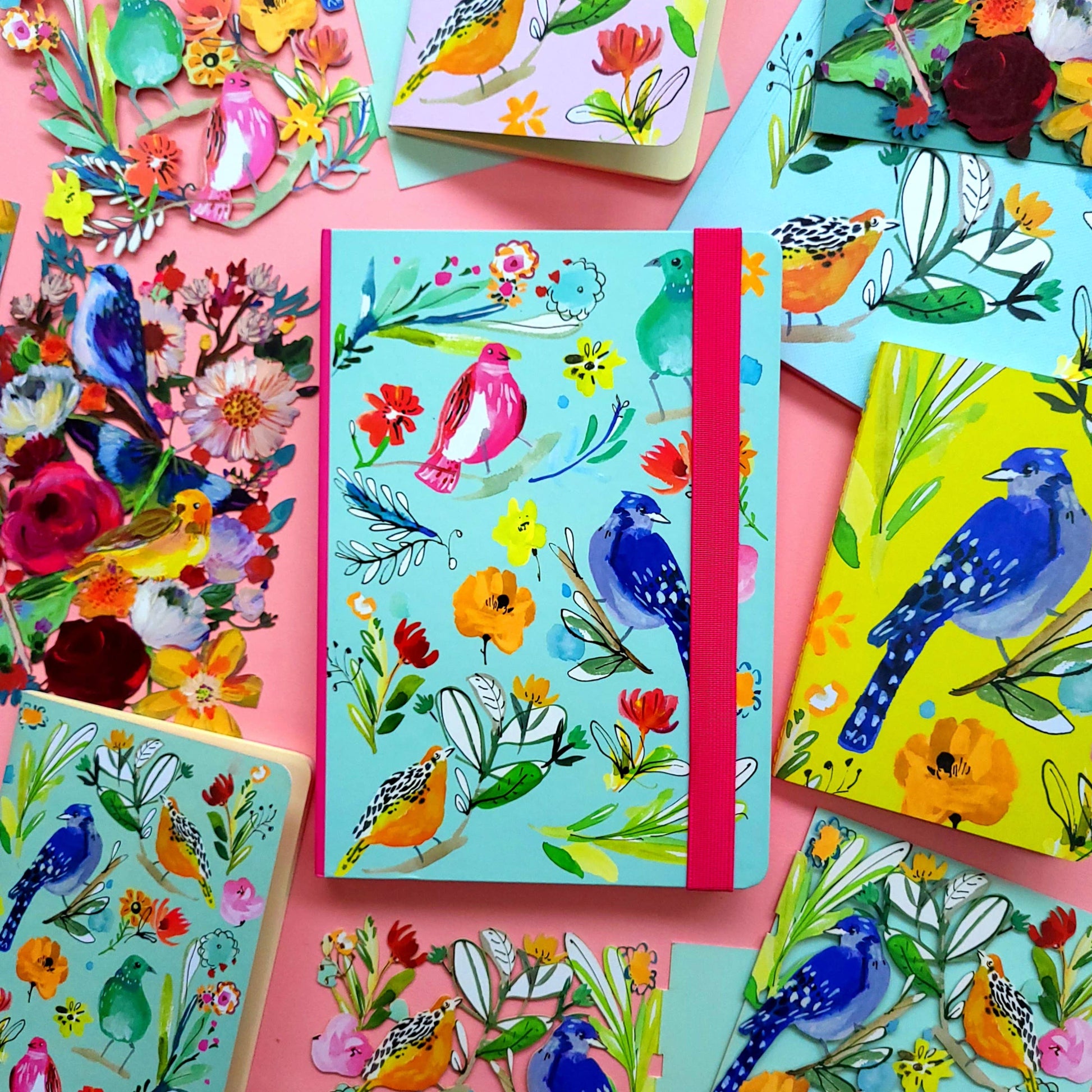 A5 journal with colorful bird illustrations and an elastic binder, featuring vibrant artwork by Jennifer Orkin Lewis.