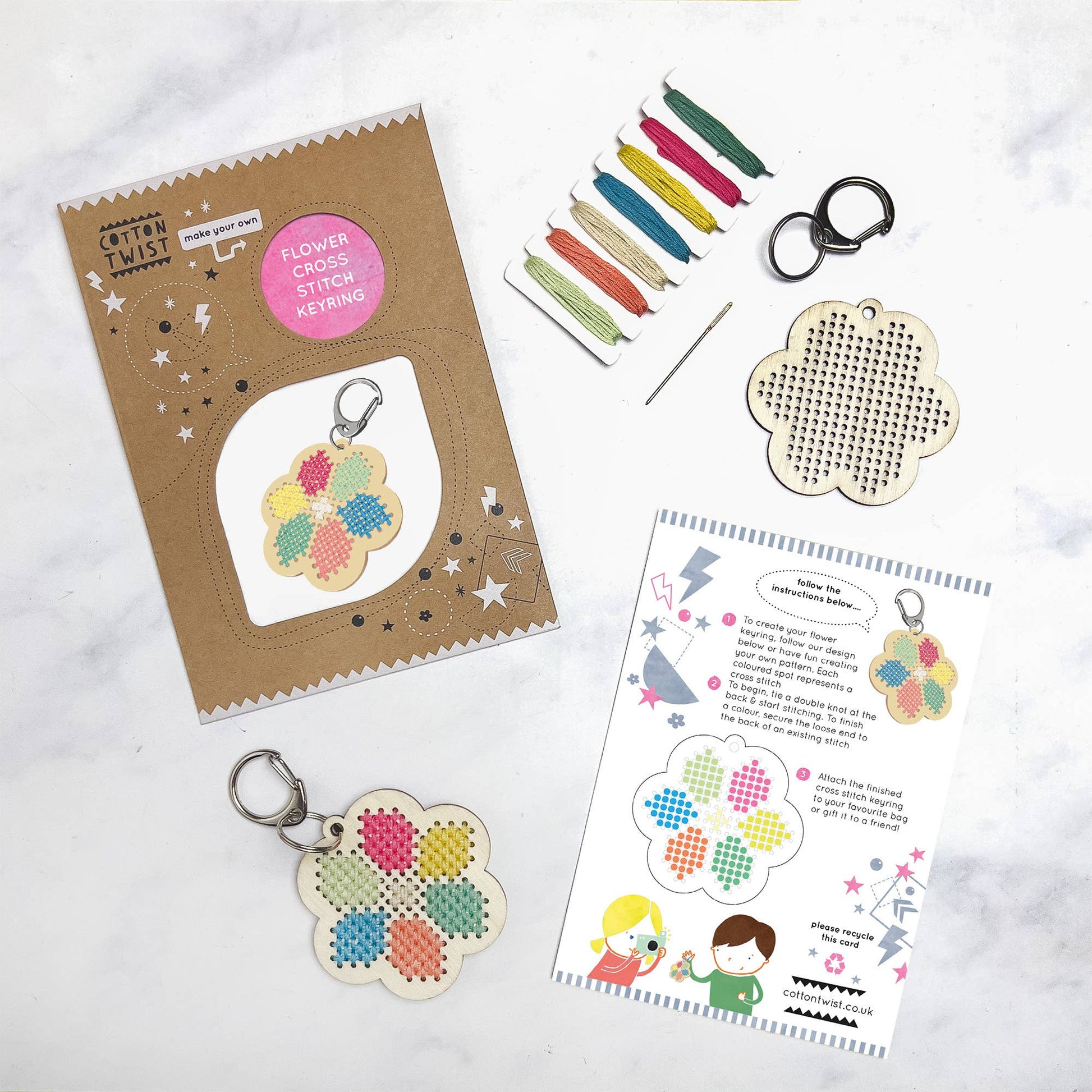 DIY flower keyring kit with colored threads, needle, and wooden flower shape for stitching.
