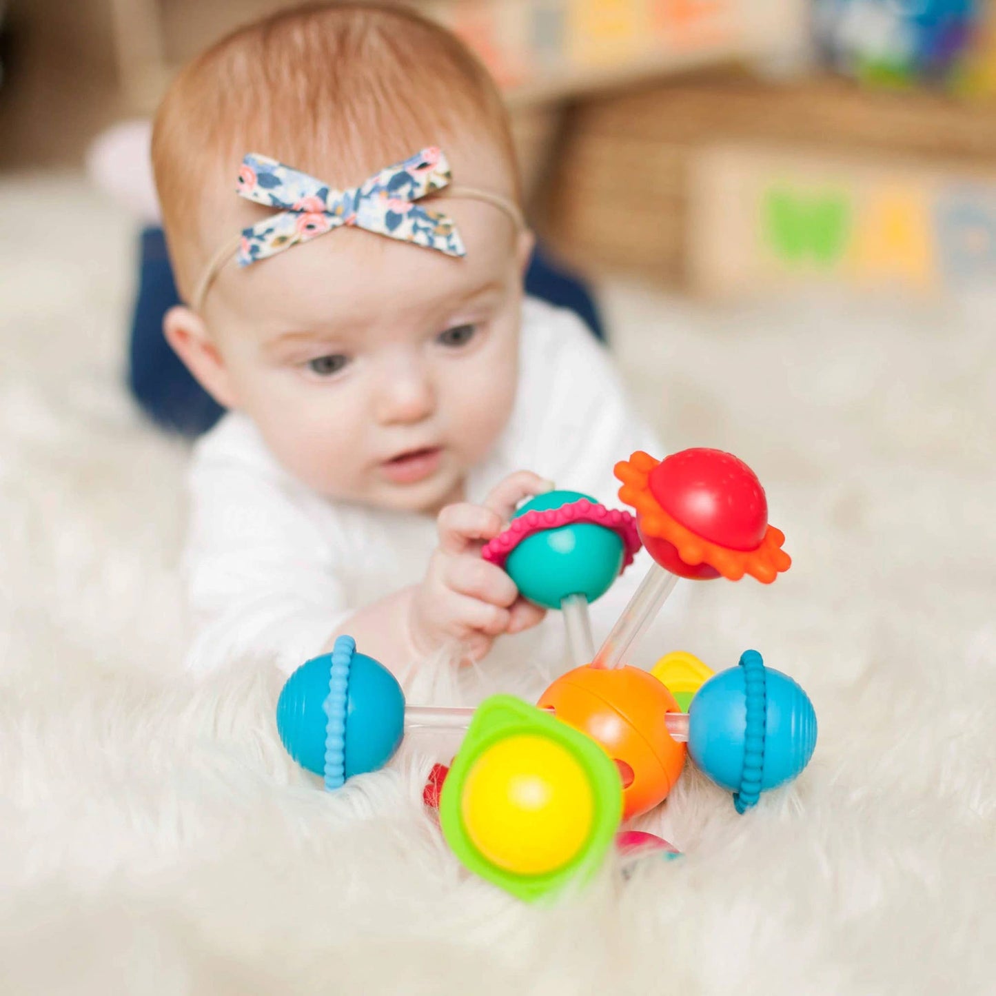 Multicolor sensory activity toy with spinning silicone rings and textured beads for baby play.