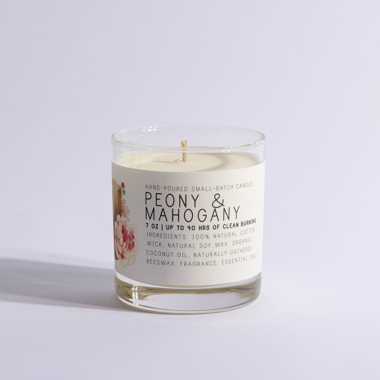 Glass jar candle labeled Peony & Mahogany with floral design