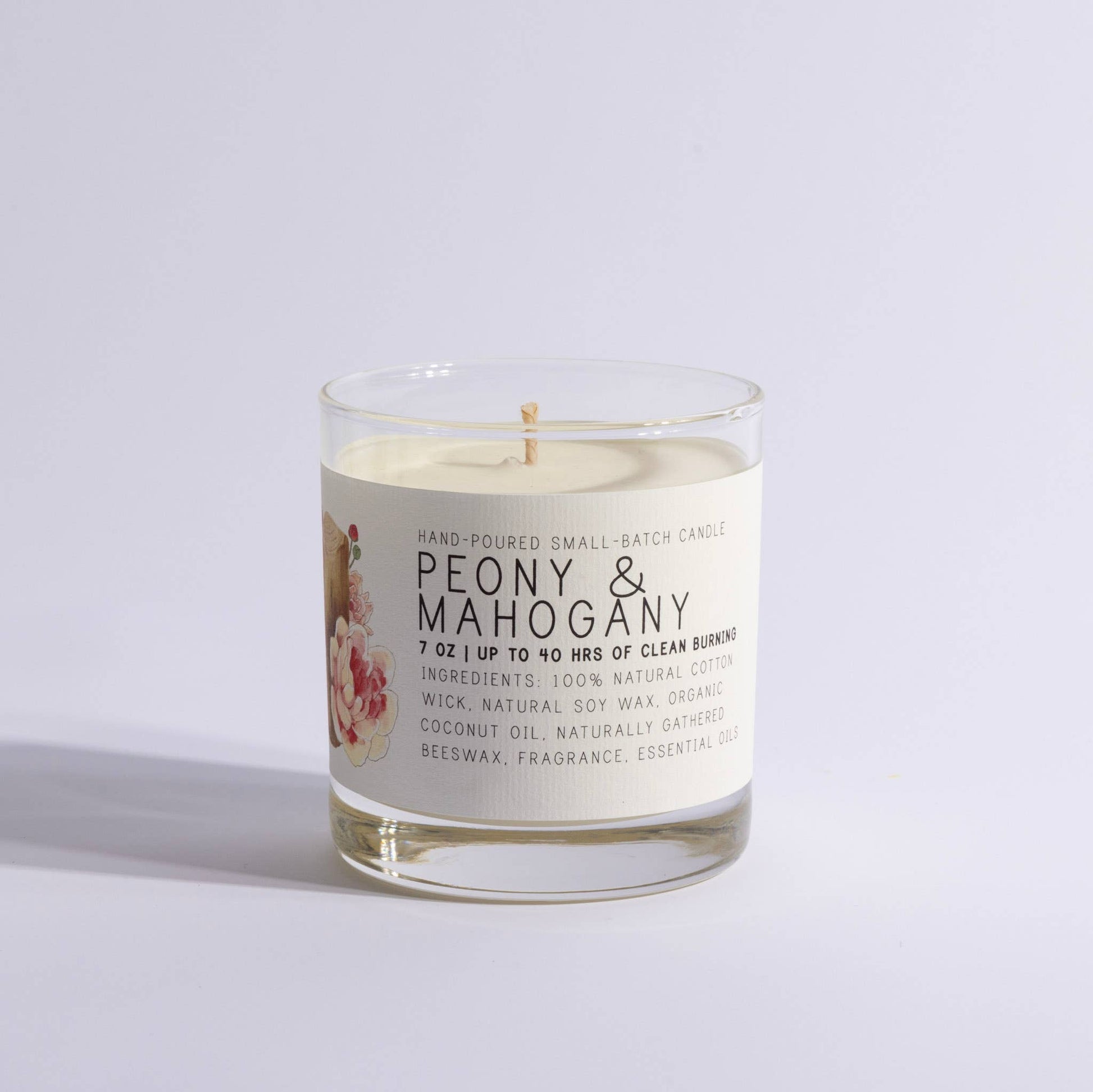 Glass jar candle labeled Peony & Mahogany with floral design
