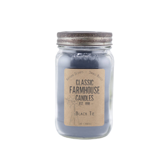 Dark gray-black candle in a mason jar labeled "Black Tie" with aged silver lid and star detail.