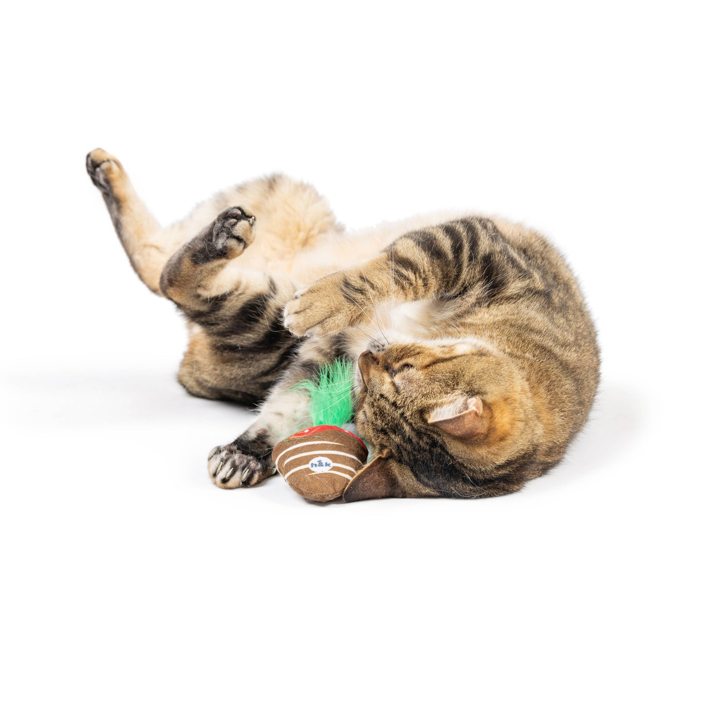 Brown and red crinkle toy with green feathers being played with by a striped cat.