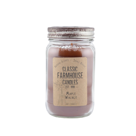 Deep maple-colored candle in a mason jar with "Maple Walnut" label and aged metal lid with star cutout.