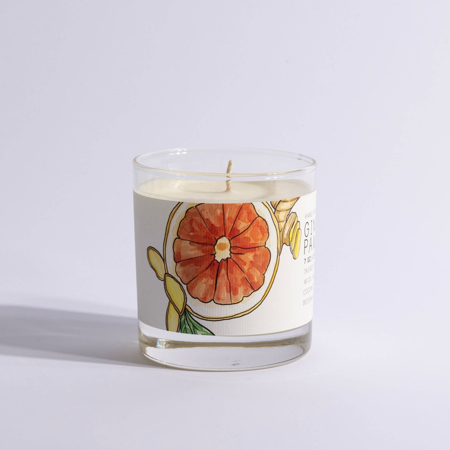 Glass candle with illustrated grapefruit and ginger label