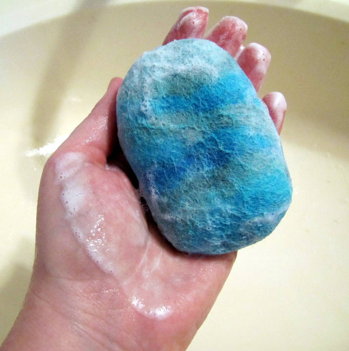 Felted soap bar in shades of blue, soft and textured for gentle cleansing.