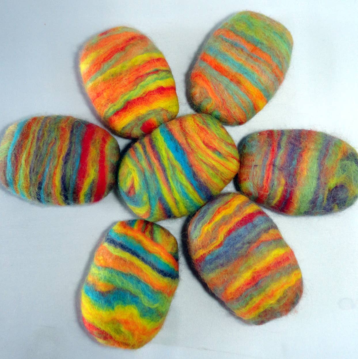 Colorful felted soap bars with vibrant rainbow stripes, perfect for a unique cleansing experience.