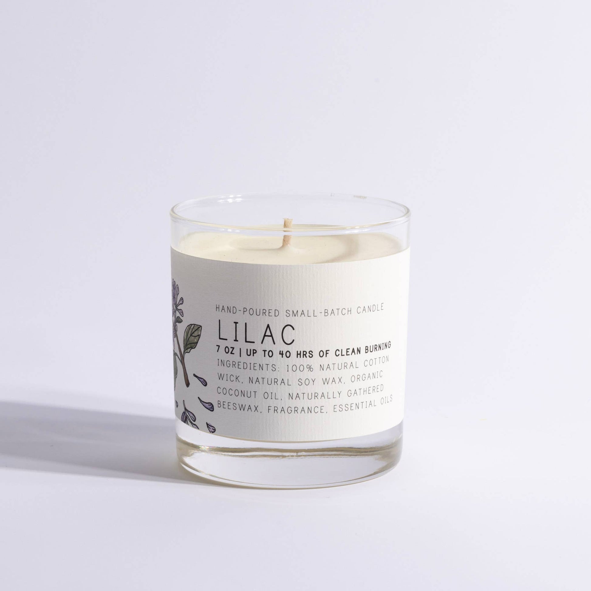 Medium lilac-scented candle in a clear glass jar with botanical label