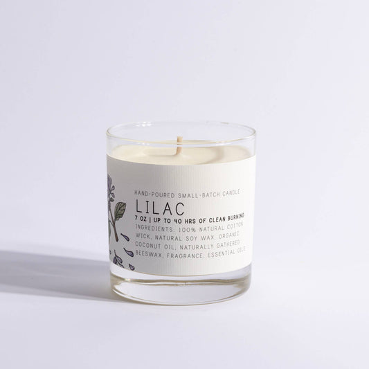 Medium lilac-scented candle in a clear glass jar with botanical label