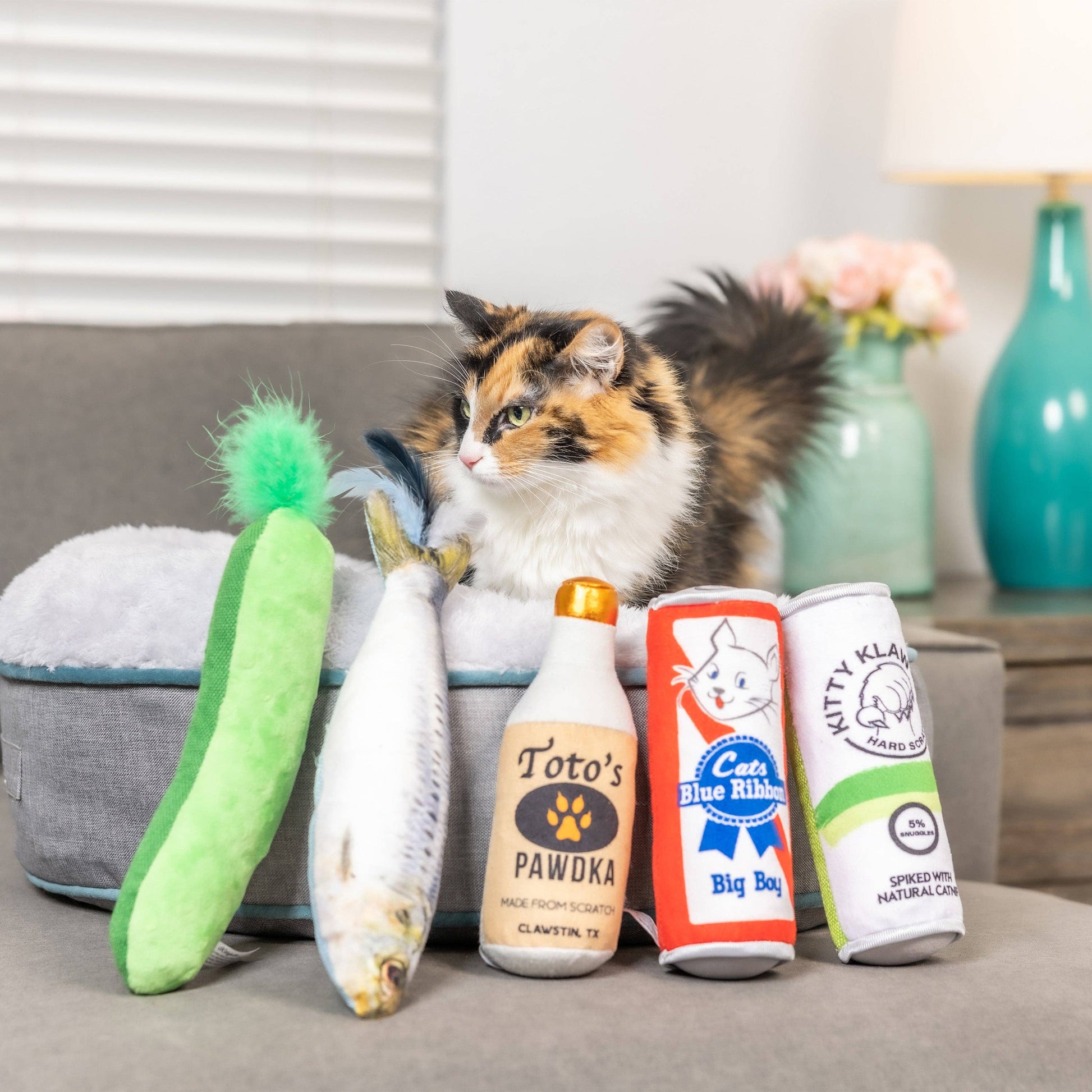 Plush cat toy set including a crinkle pickle, fish, bottle, can, and tube, all filled with catnip.