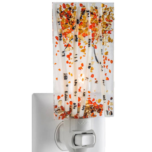 Fused glass night light featuring an aspen tree design with autumn colors and a warm glow.