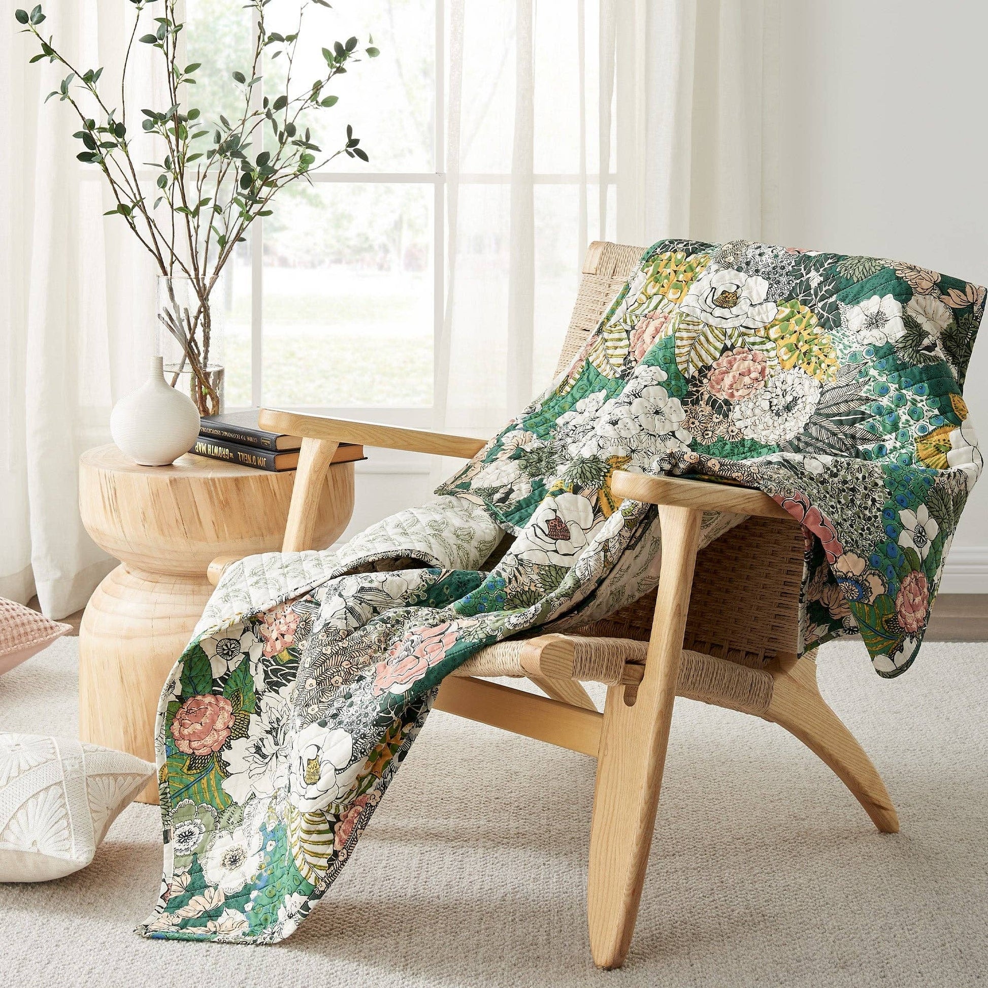 Floral quilted throw draped over a wooden chair in a sunlit room