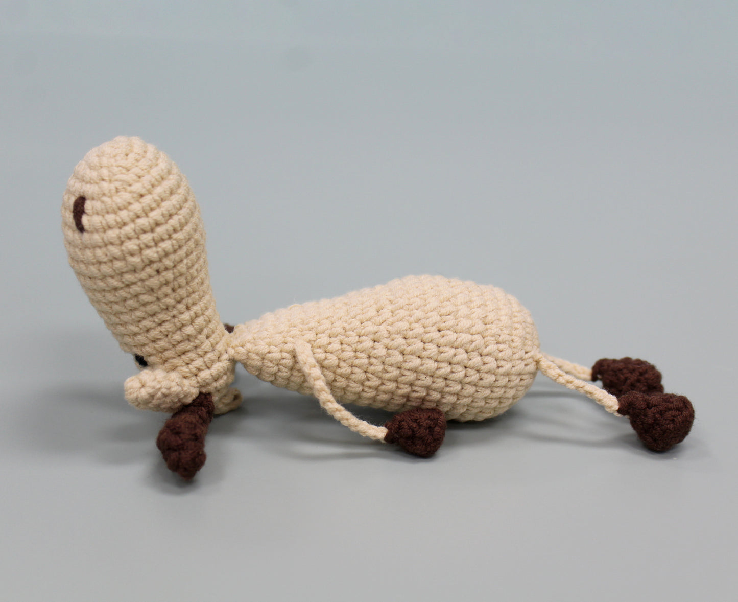 Handmade crochet moose keychain in cream and brown with plush texture.