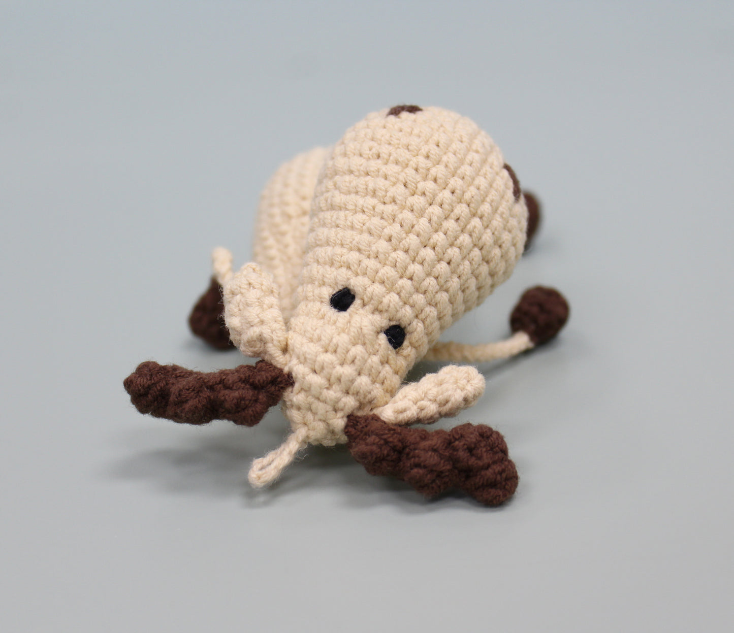Handmade crochet moose keychain with cream body and brown antlers and legs, plush and adorable.